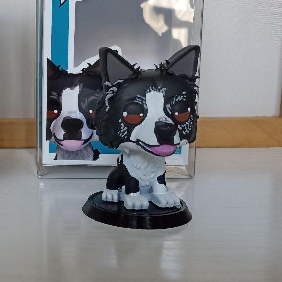 Hero Pop Mascota Personalizada – perro negro y blanco sobre peana, frontal con caja